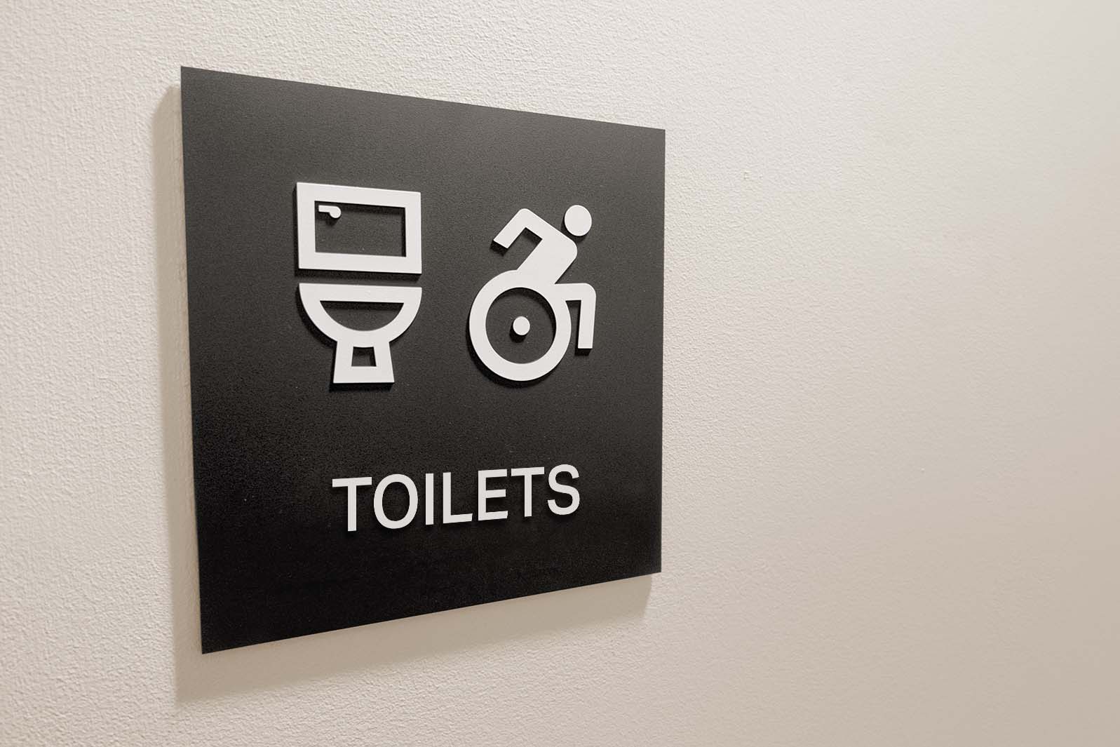 Toilet signs should incorporate well-contrasted tactile text and symbols, benefitting both sighted and blind/partially sighted users.